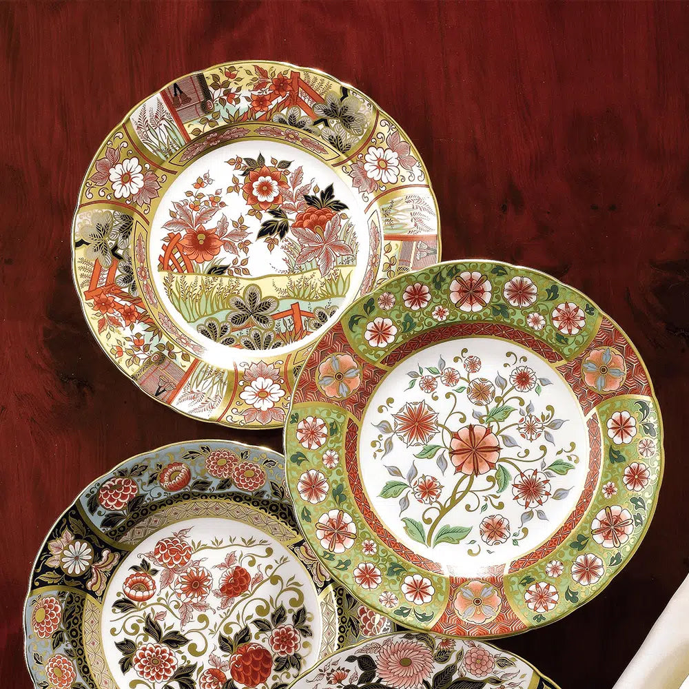 Set of decorative plates with floral and nature-themed designs on a wood table