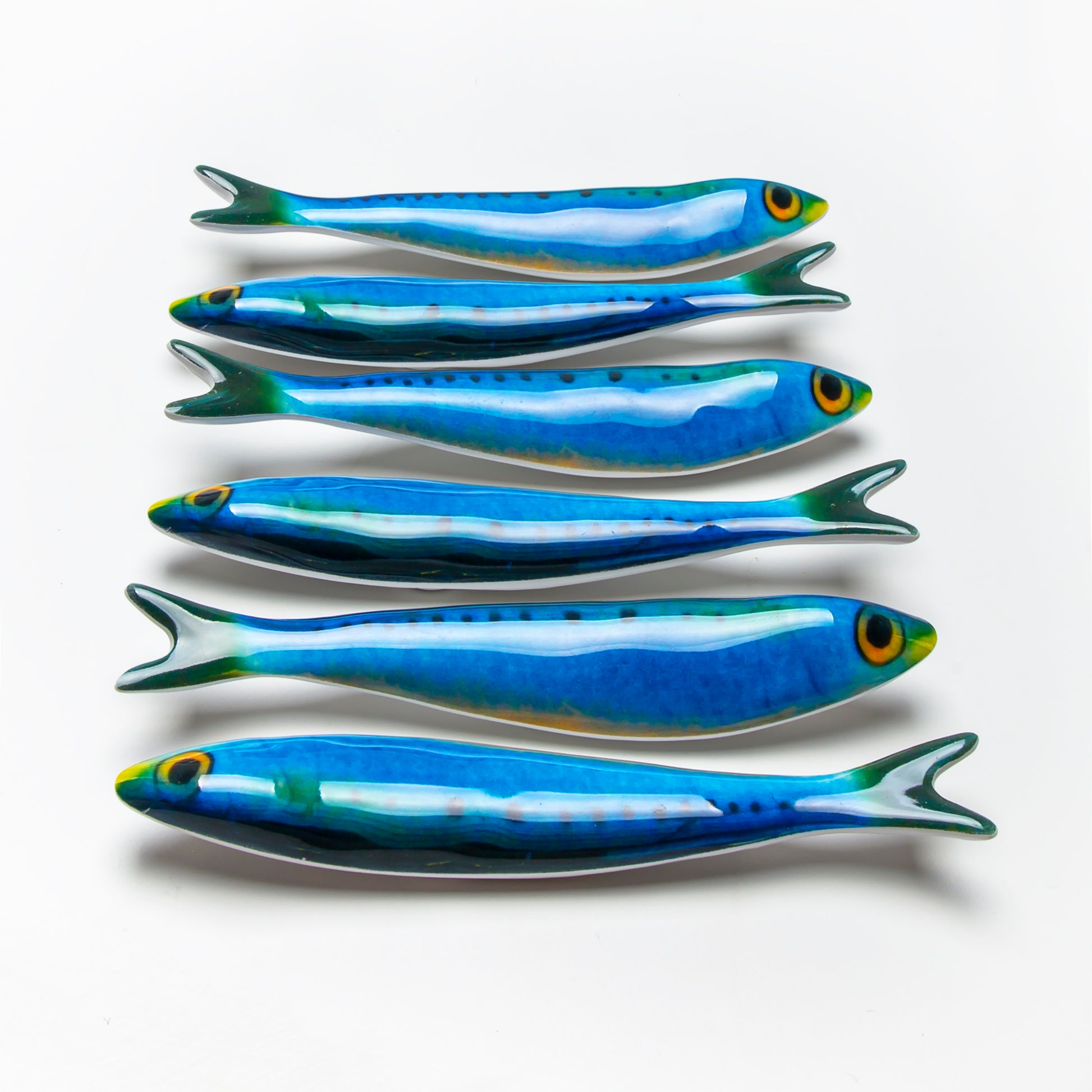 A set of six blue fish-shaped melamine magnets against a white background.