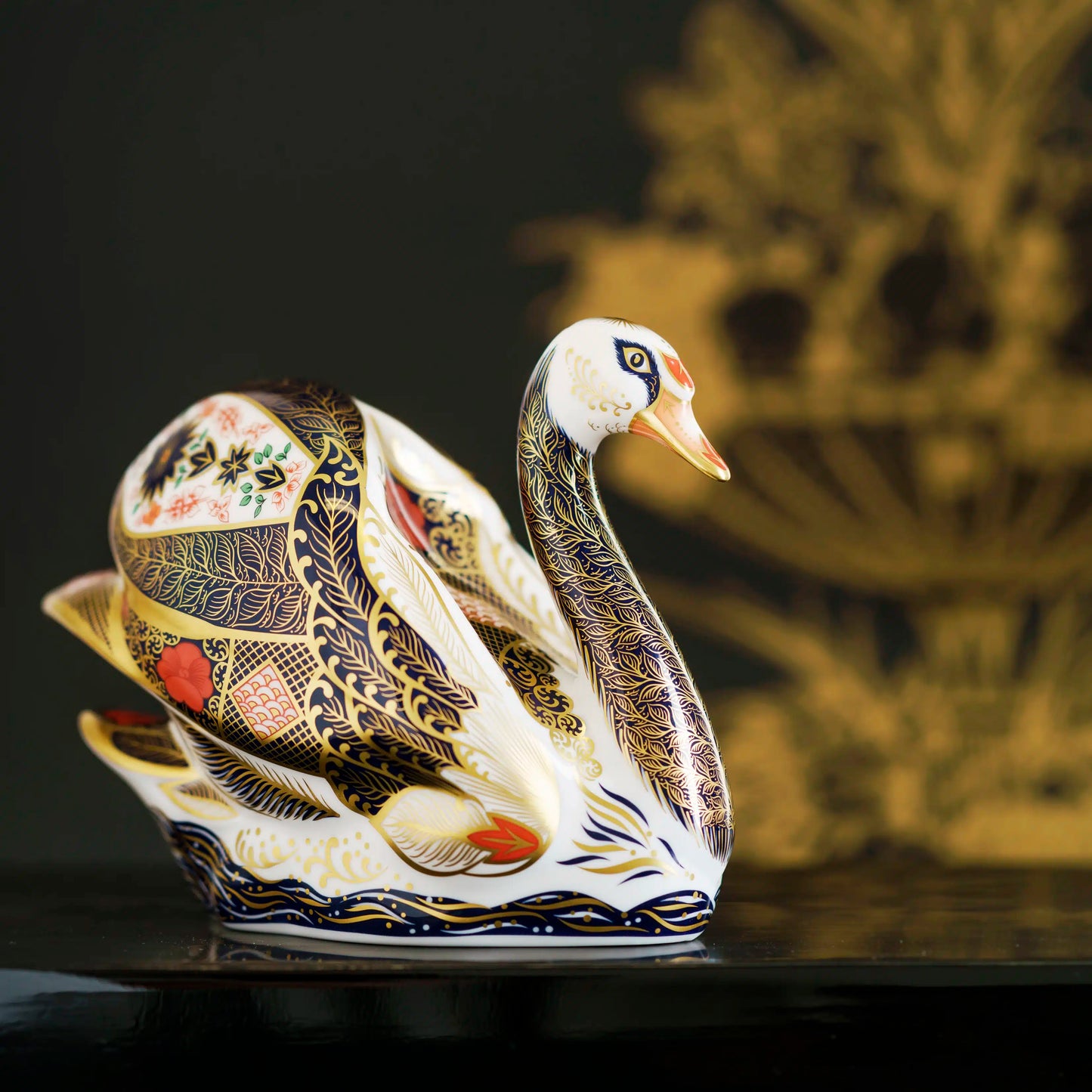 Decorative swan figurine with intricate patterns on a dark background