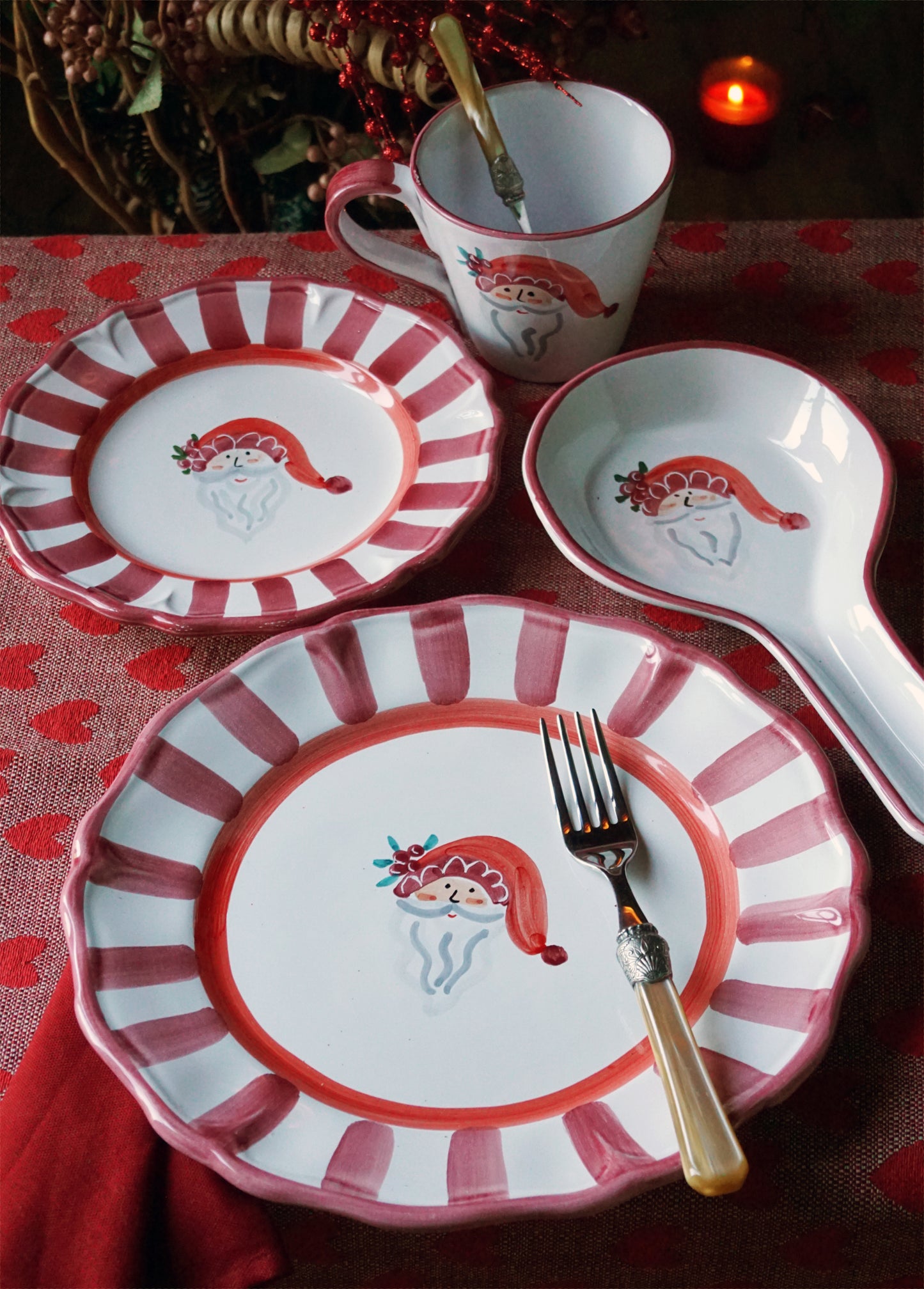 Christmas-themed ceramic tableware set with Santa Claus design on a red and white striped pattern.