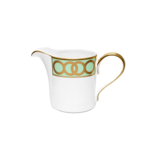 White creamer with gold and green design on a white background