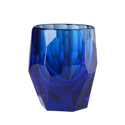 Blue faceted glass tumbler on a white background