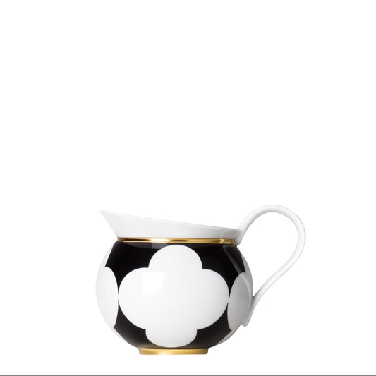 A black and white geometric patterned porcelain creamer with gold accents on a white background.