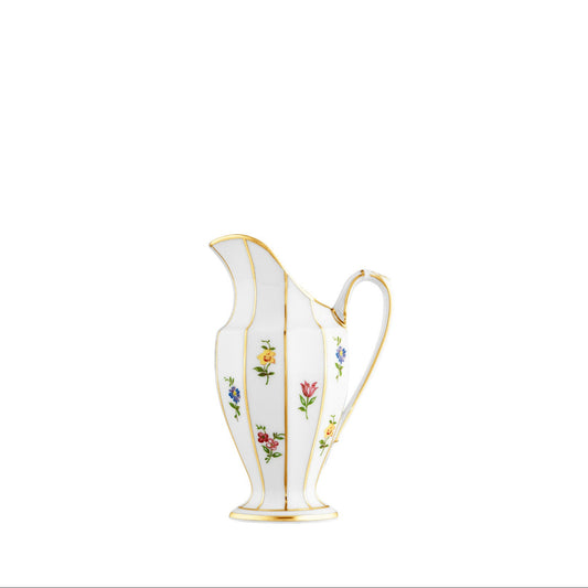 A white porcelain creamer with floral patterns and gold accents.