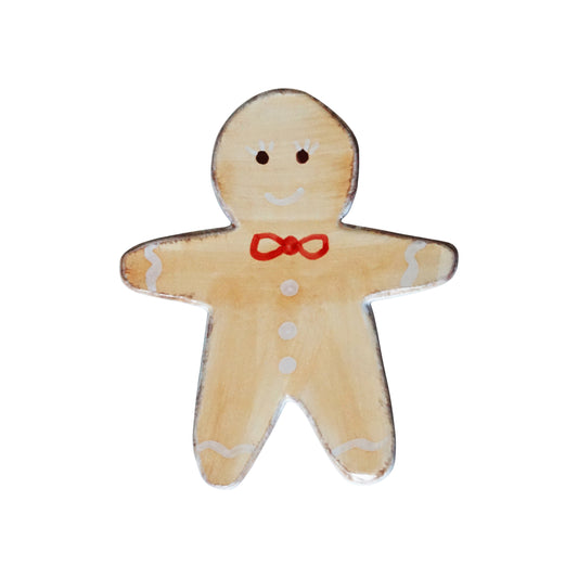 Gingerbread man trivet with a red bow tie on a white background