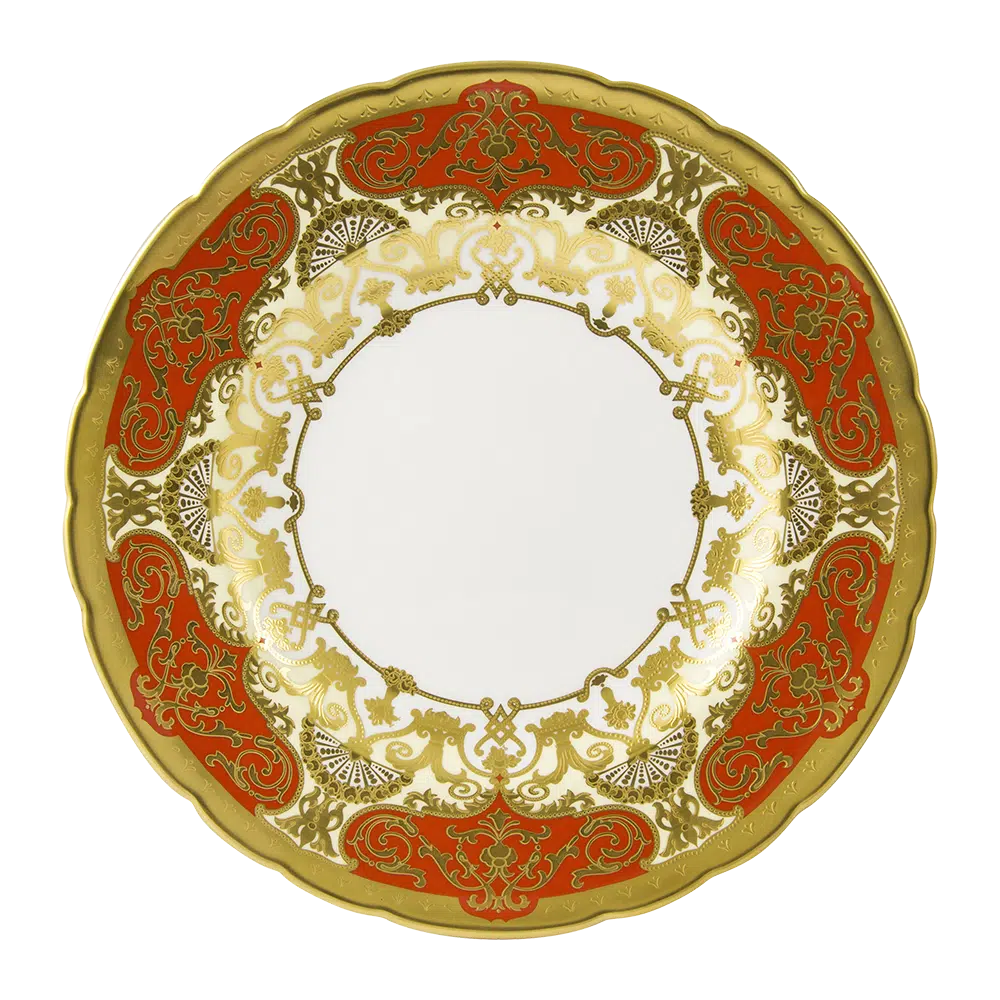 Decorative plate with gold and red patterns on a white background
