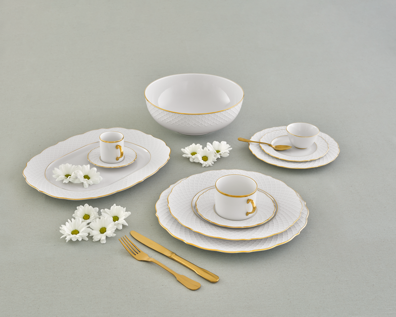 Porcelain dinnerware set with white plates, bowls, and cups on a gray background