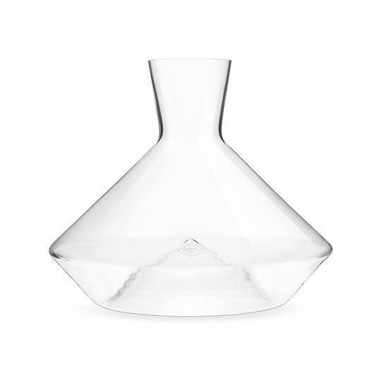 A clear, handblown glass decanter with a large base and a minimalist design, featuring a self-confident size and a filigree structure.