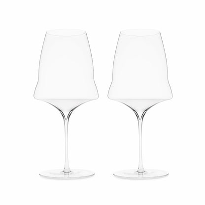 A set of two hand blown wine glasses with a modern design, featuring a large bowl with a kink and a long narrow stem, on a white background.
