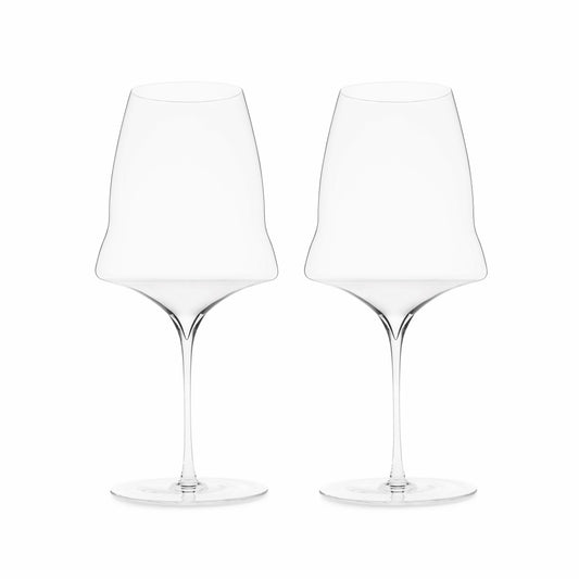 A set of two hand blown wine glasses with a modern design, featuring a large bowl with a kink and a long narrow stem, on a white background.