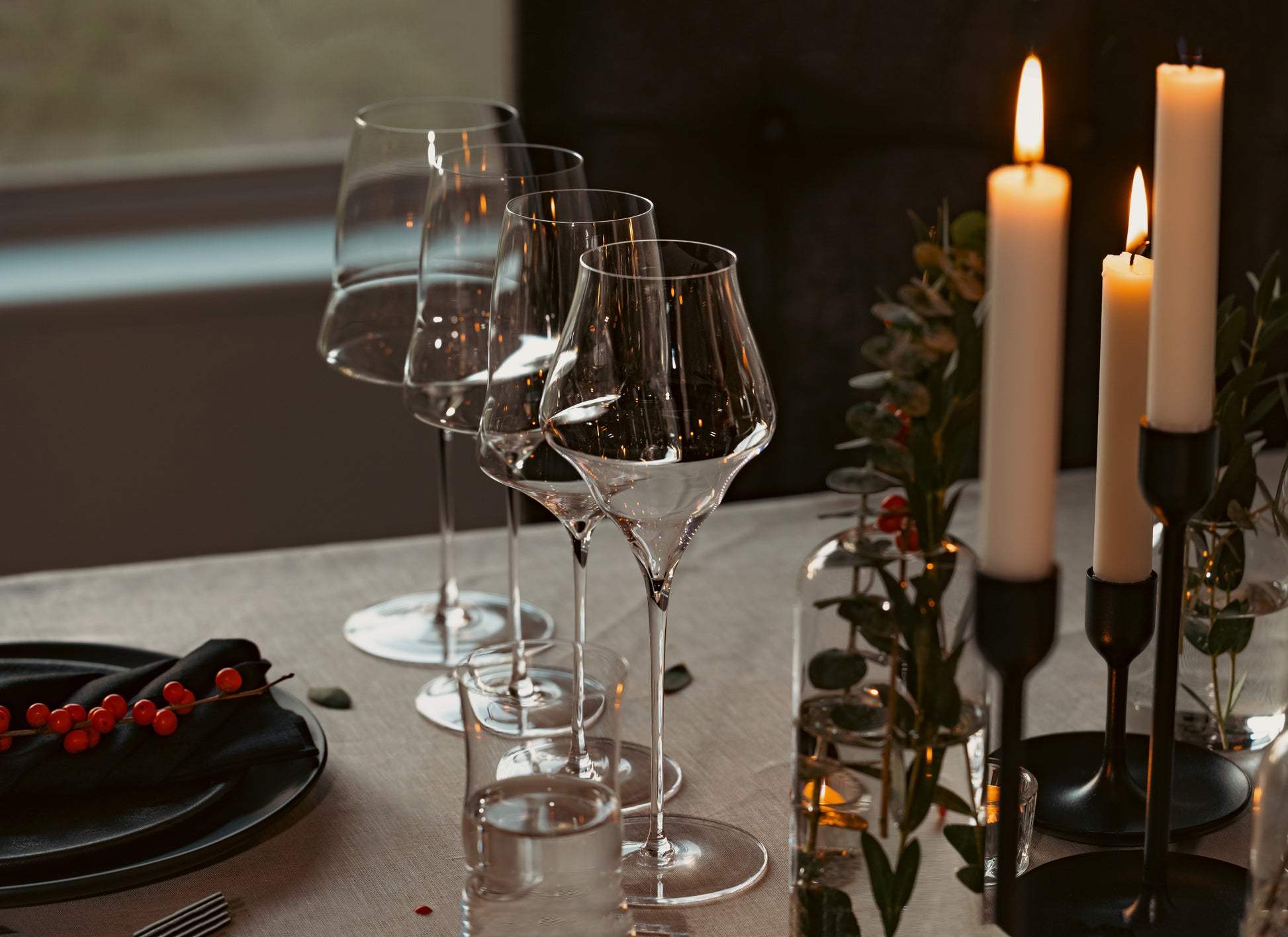Set of hand-blown luxury glasses on a dining table with candles