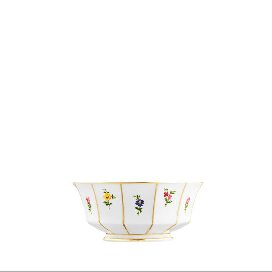 A white porcelain bowl with gold trim and small floral decorations arranged in a pattern around the edge.