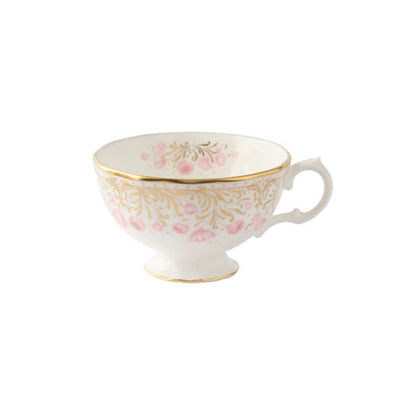 A fine bone china tea cup and saucer with a white base and pink floral pattern and a gold border.