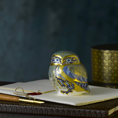 Decorative bone china owl figurine on a surface with a dark background