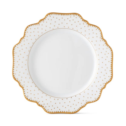 White plate with polka dots and gold decorative edge on a white background