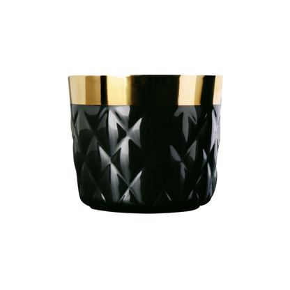 A black luxury porcelain champagne tumbler with a quilted texture with a gold rim and interior, against a plain background.