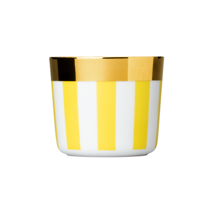 A white porcelain champagne tumbler with butter yellow stripes and a gold rim at the top.