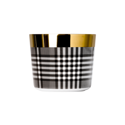 A black and white porcelain champagne tumbler with a gold rim and interior, featuring a geometric pattern.