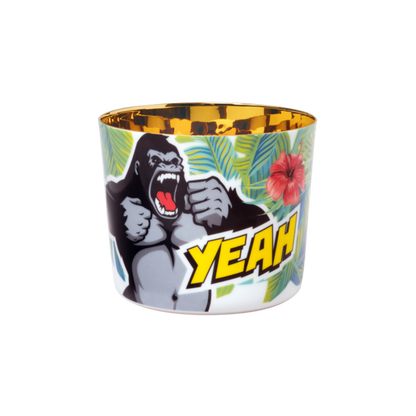A porcelain champagne tumbler with a colorful illustration featuring a gorilla and the text 'YEAH' on a yellow and green background, with a golden interior.