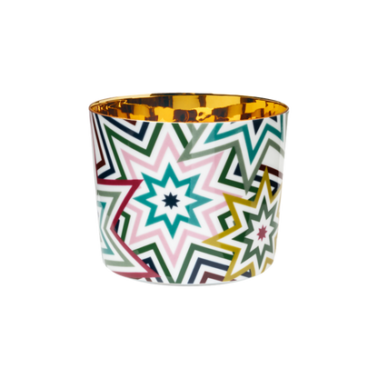 A multicolored porcelain champagne tumbler with a gold interior and a design that includes stars in a rainbow of colors.