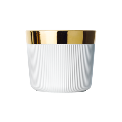 A matte white porcelain champagne tumbler with a gold rim and interior, against a plain background.