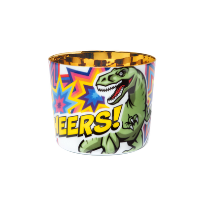A porcelain champagne tumbler with a colorful illustration featuring a T-rex and the text 'CHEERS' on a colorful star background, with a golden interior.