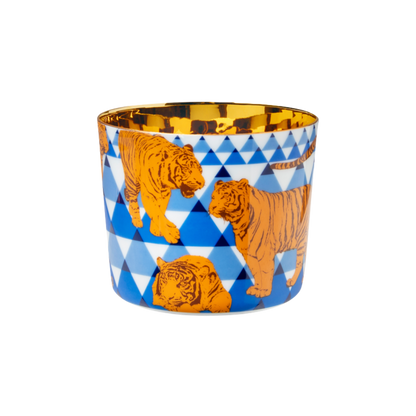 A multicolored porcelain champagne tumbler with a gold interior, decorated with orange tigers against a blue patterned background.