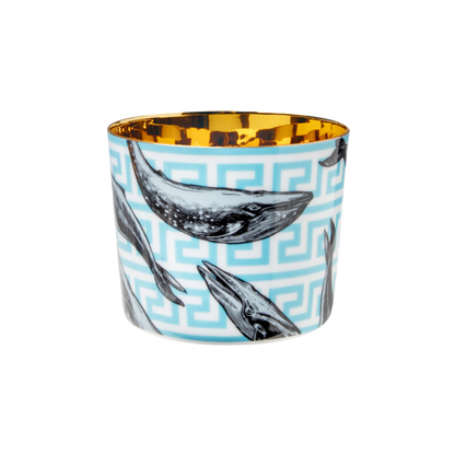 A multicolored porcelain champagne tumbler with a gold interior, decorated with blue whales