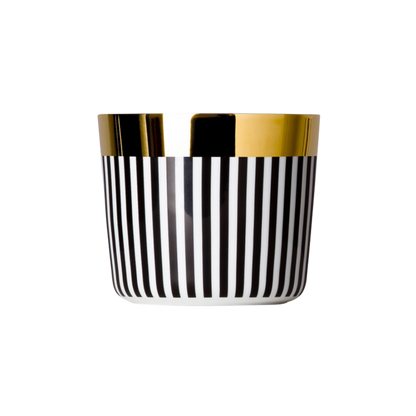 A white porcelain champagne tumbler with a black pattern and gold trim on the top rim.