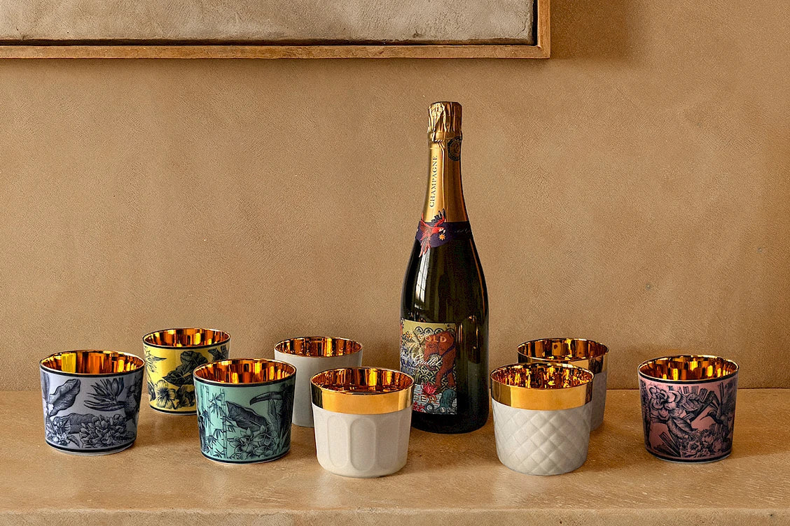 Bottle of champagne with luxury porcelain tumblers with 24k gold interiors 