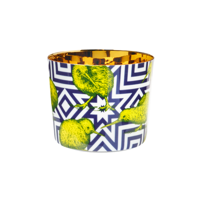 A multicolored porcelain champagne tumbler with a gold interior, decorated with green kiwi against a blue patterned background