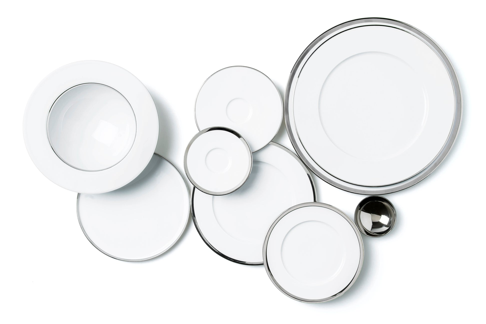 Set of white porcelain plates with silver rims on a white background