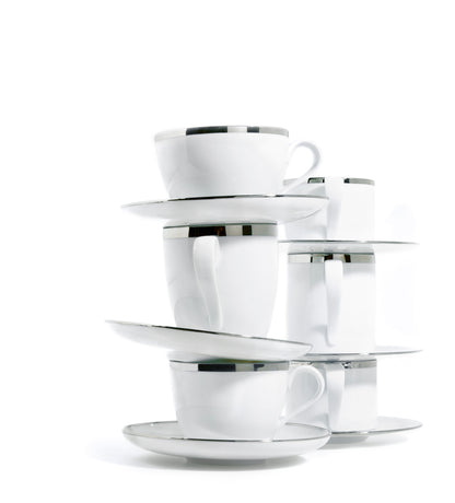 Set of white porcelain coffee & tea cups and saucers with silver rims on a white background