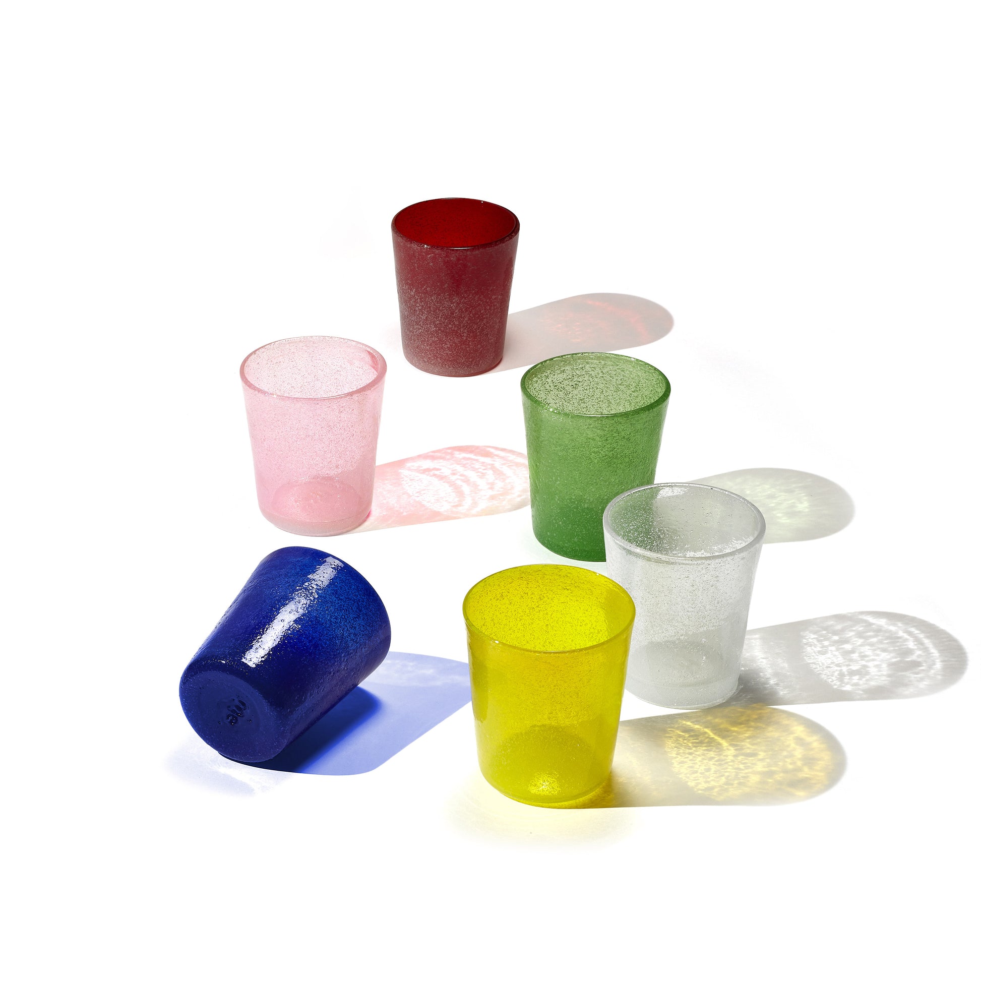 Set of colorful glass tumblers on a white background