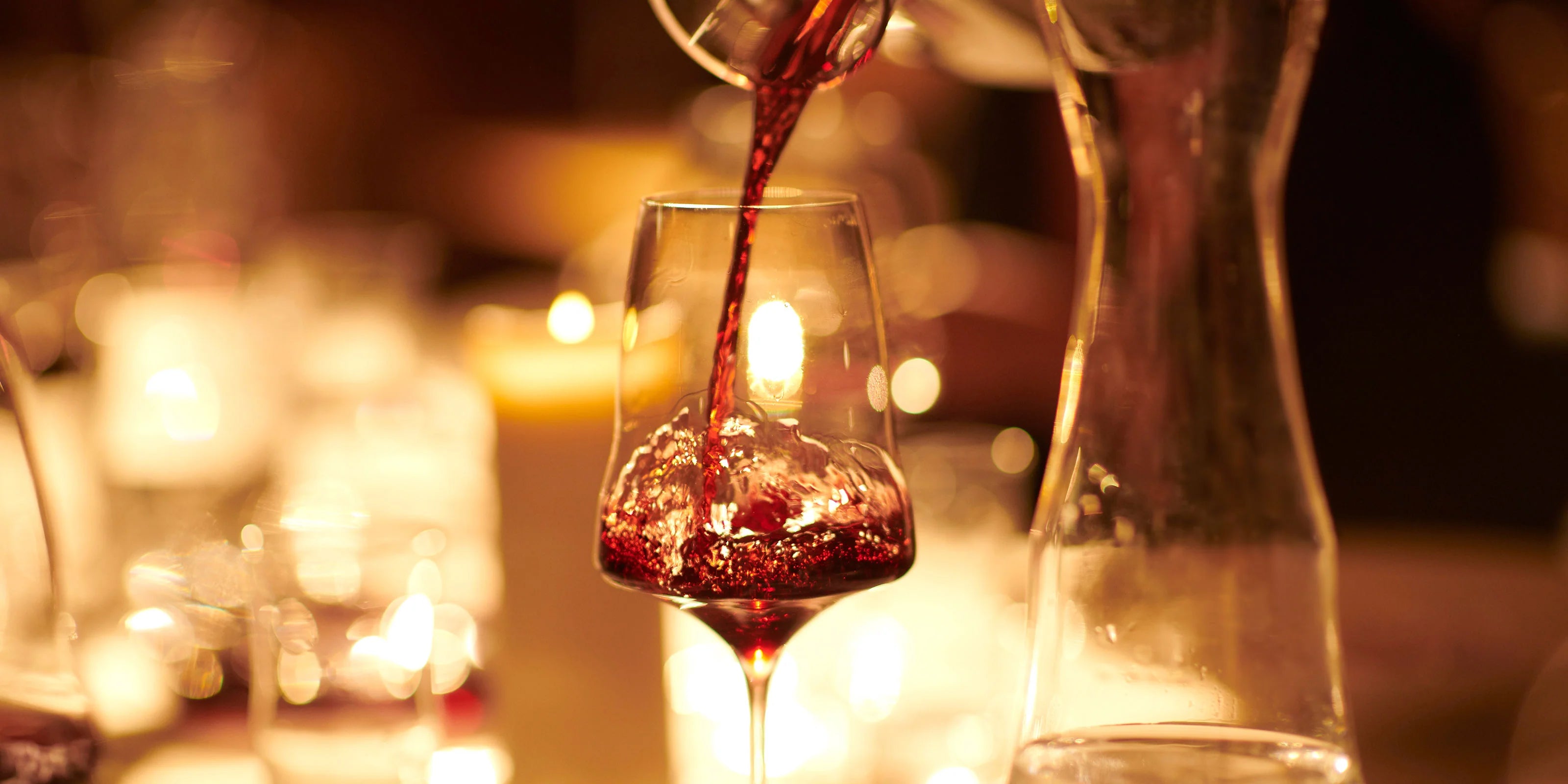 Red wine being poured into a glass with a blurred candlelit background. Taste: Supreme indulgence for all the senses.
The iconic shape with its curve brings out the aromas to perfection. No other glass touches wine with such effortless grace.